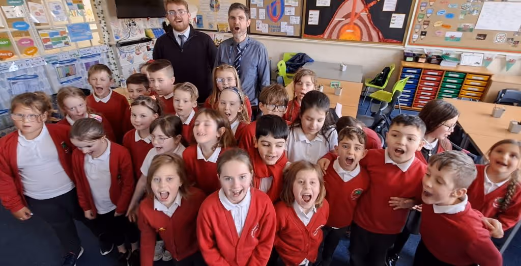 Year 4 pupils singing in a classroom.