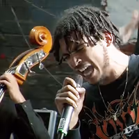 A picture of the rapper Eyez on stage rapping.
